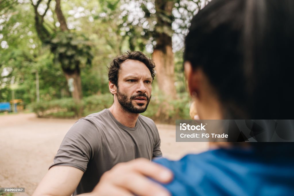 Mid adult woman feeling bad and being helped by her husband at the park