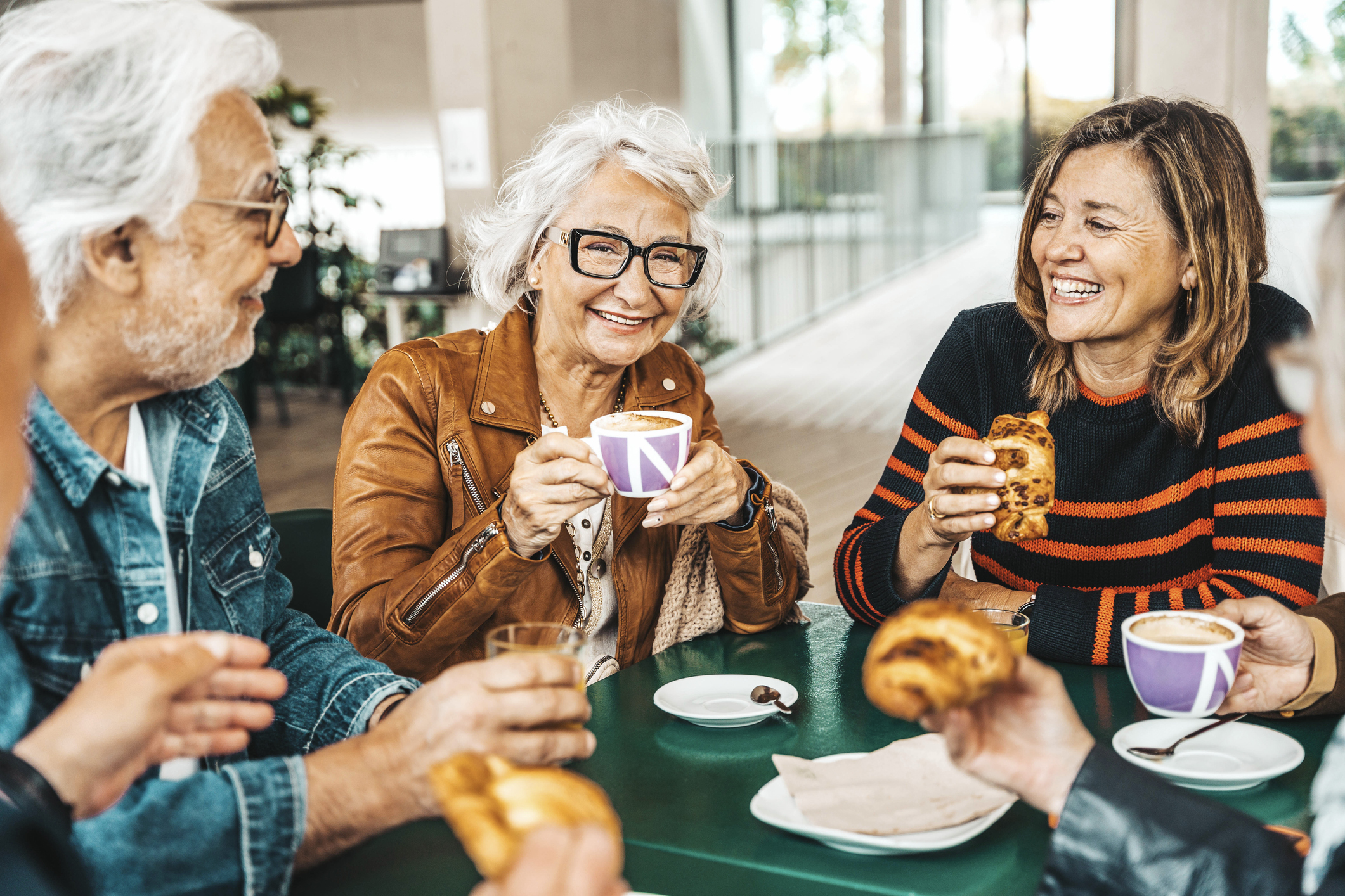 Happy senior people having breakfast sitting at cafe bar - Group of older friends having lunch at restaurant table - Food and beverage life style concept